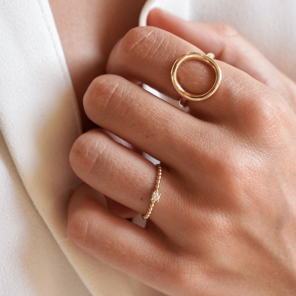 Gold ring with a small diamond on a white background