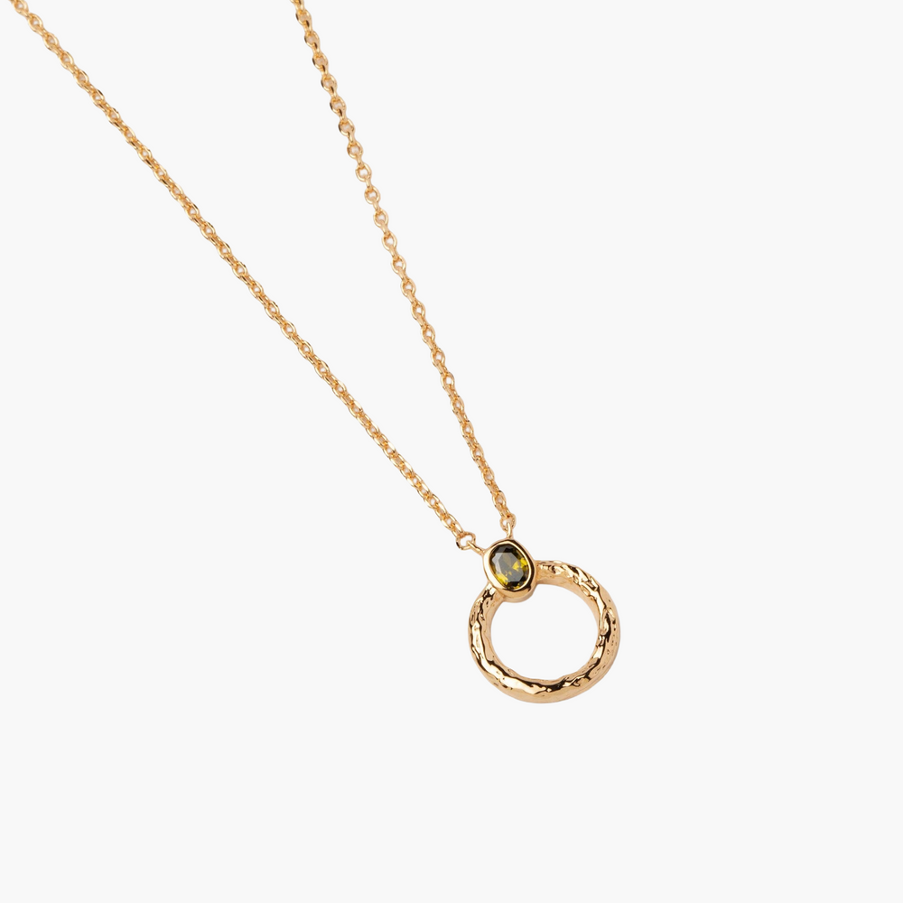 Gold necklace with a circular pendant on a white background
