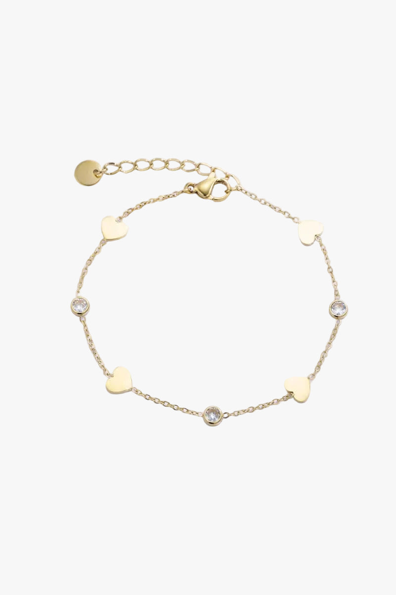 Gold bracelet with heart-shaped charms on a light blue background