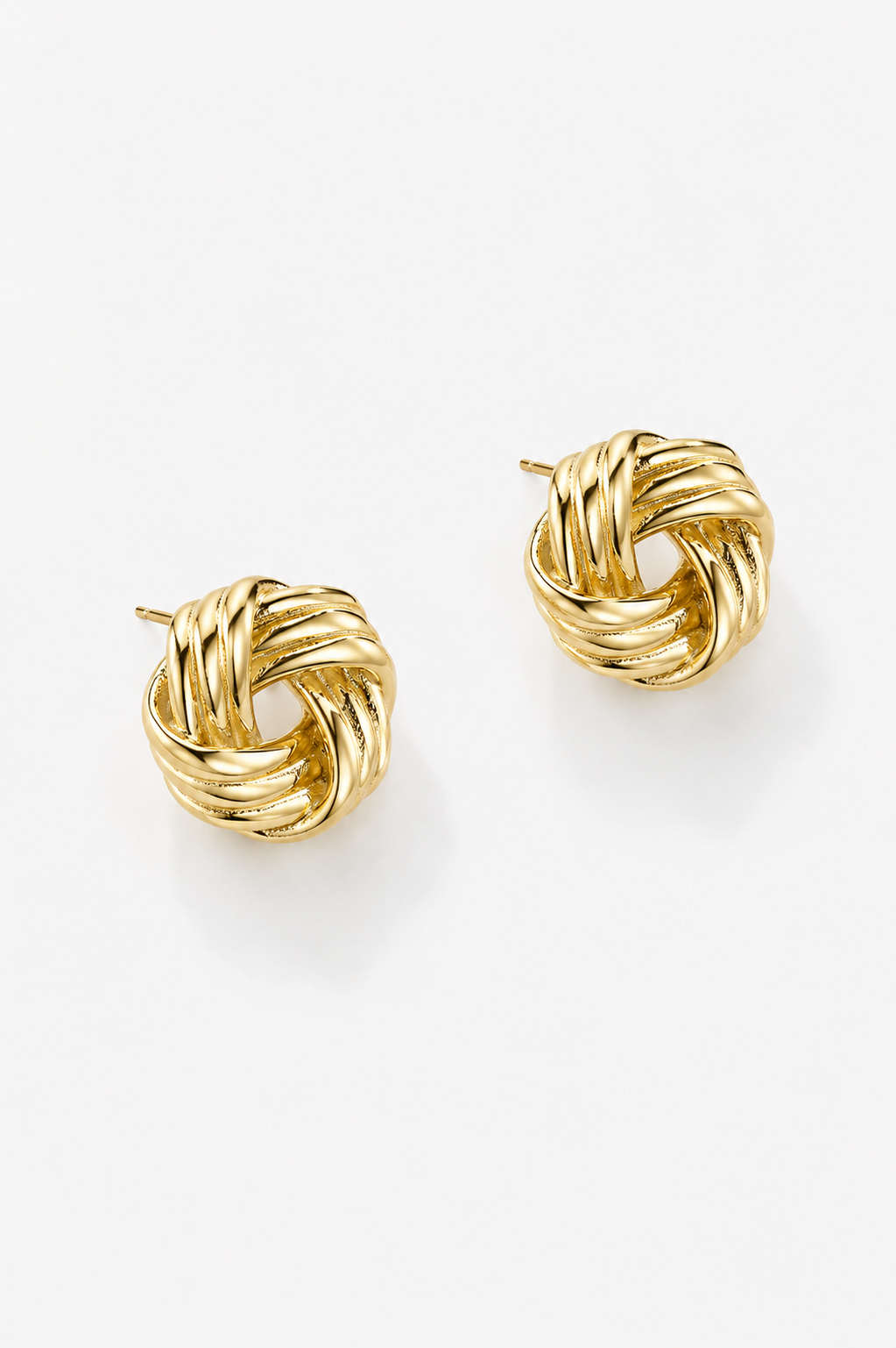 Pair of gold knot earrings on a white background
