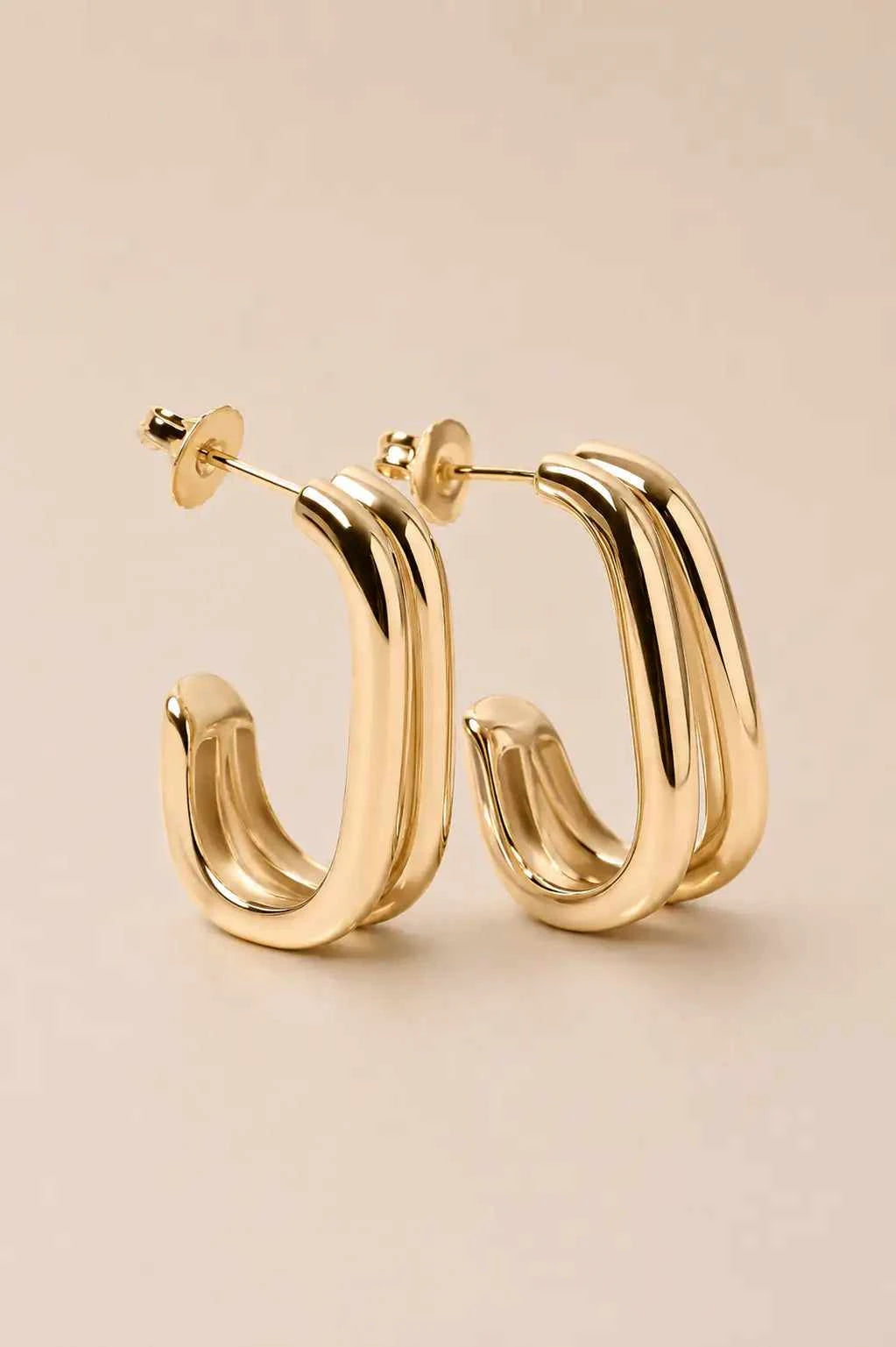 Mona earrings with an elegant gold-tone finish and modern minimalist statement design