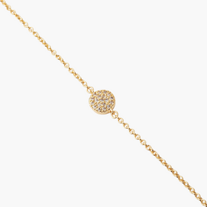 Gold necklace with a round, diamond-studded pendant on a white background