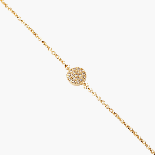 Gold necklace with a round, diamond-studded pendant on a white background