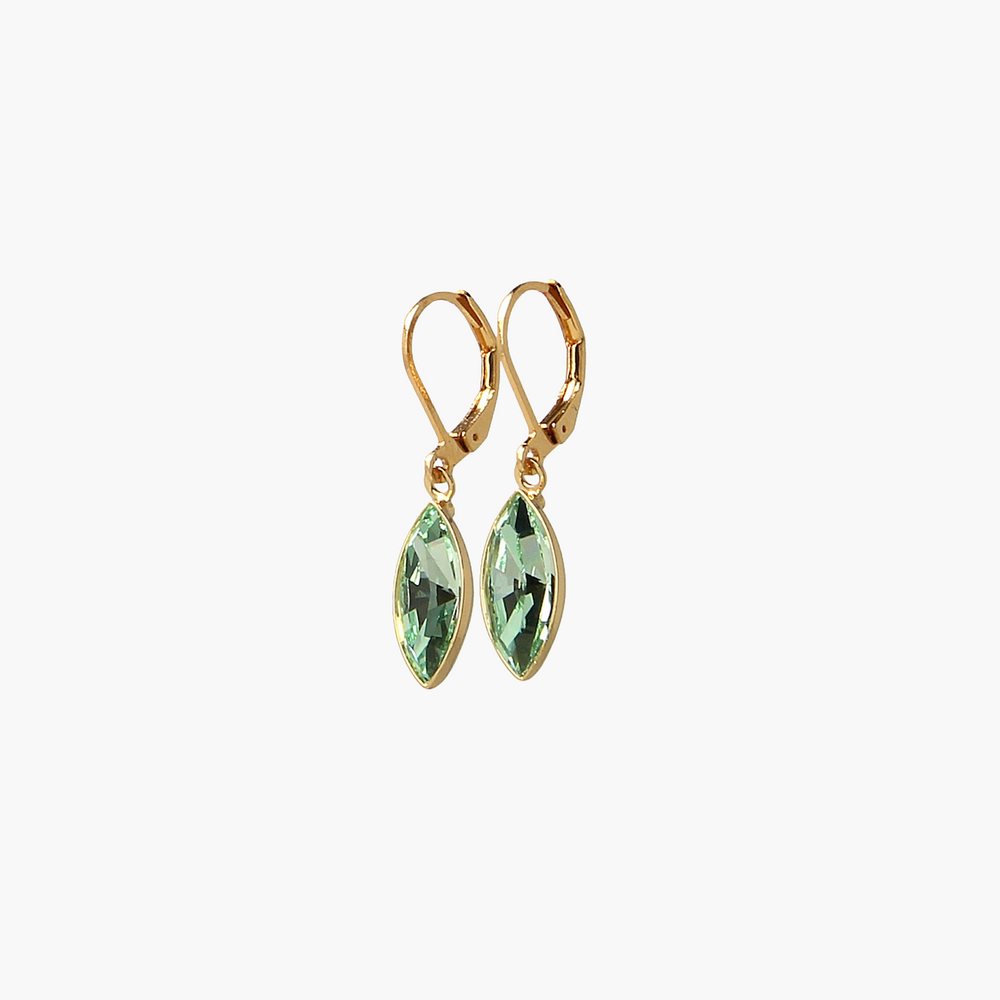 Gold earrings with green gemstones on a white background