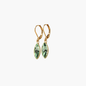 Gold earrings with green gemstones on a white background