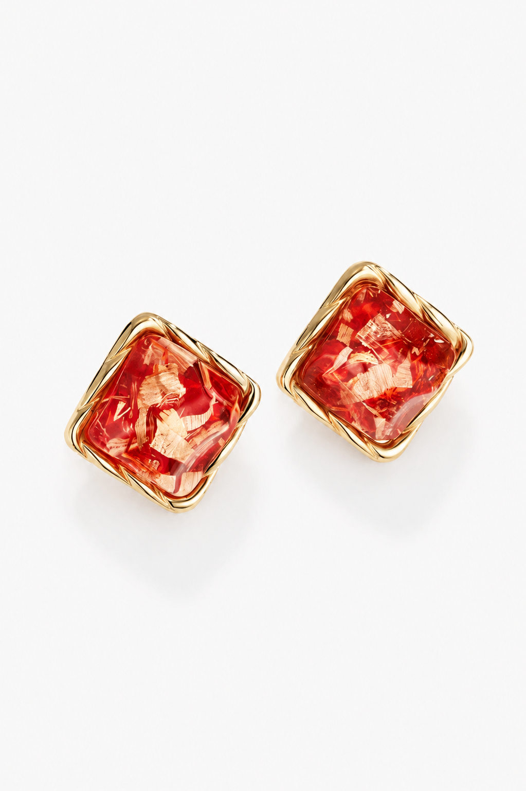 Pair of square-shaped earrings with red marbled design on a white background