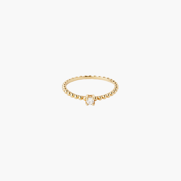 Gold ring with a small diamond on a white background
