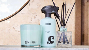 Janzen Room Spray, Musk Jasmine & Joy, 500ML bottle on a shelf with a candle and diffuser.