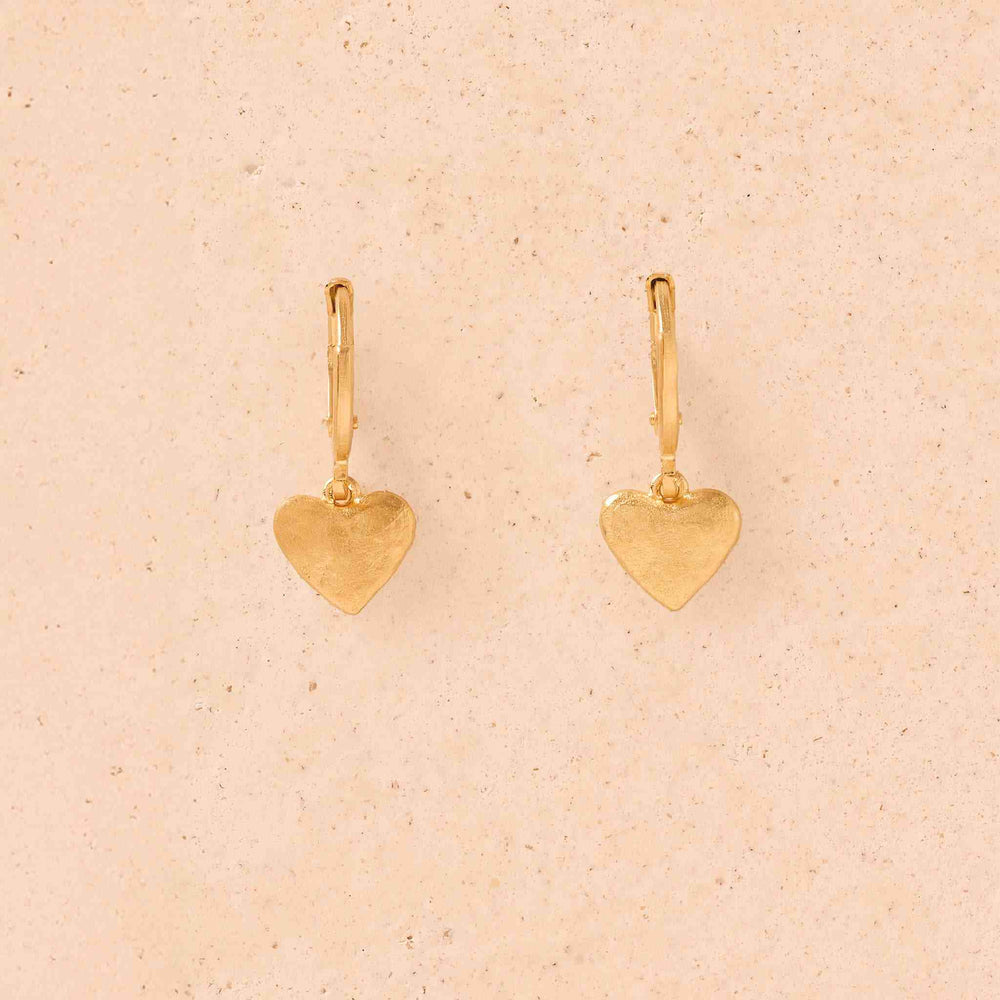 Gold heart-shaped earrings on a white background