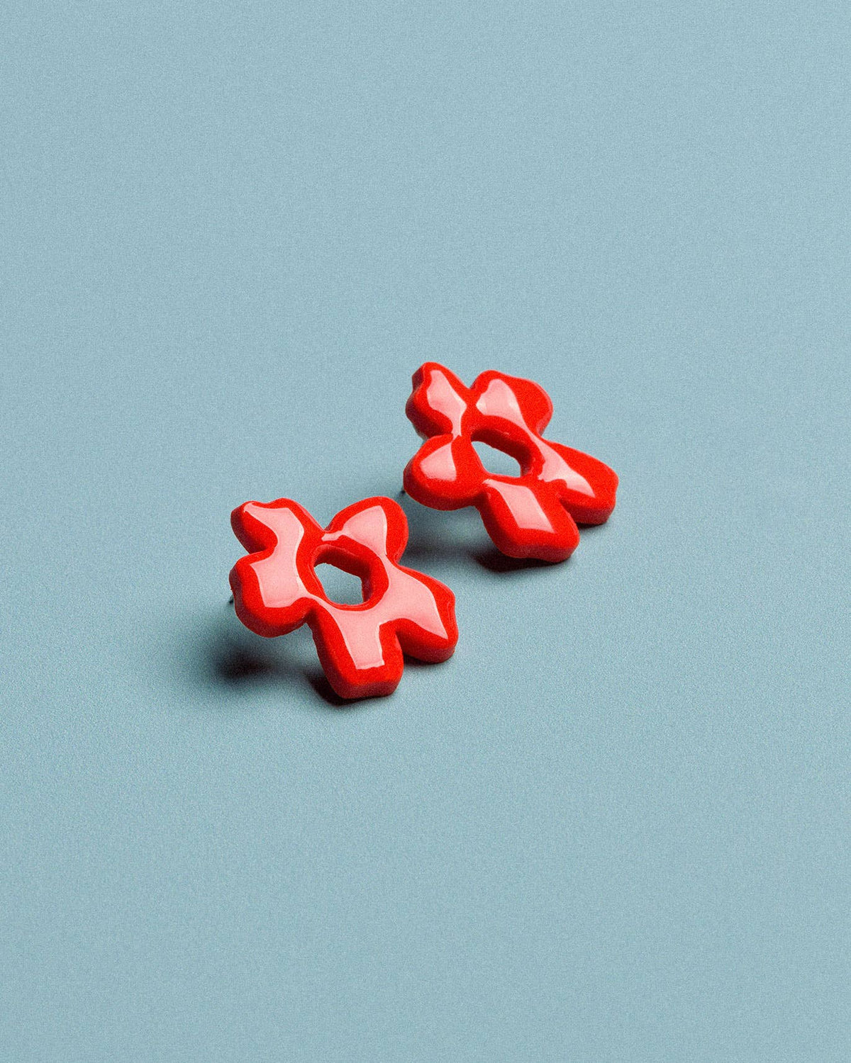 Handmade floral earrings in red polymer clay, designed as a lightweight statement jewellery accessory

