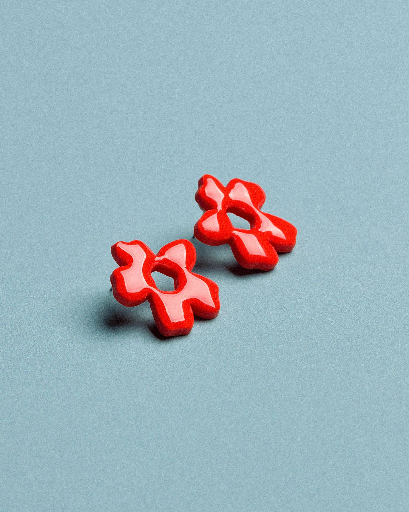 Handmade floral earrings in red polymer clay, designed as a lightweight statement jewellery accessory
