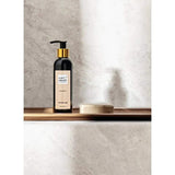 Liet & Joliet Floral Happiness Showergel bottle on a wooden shelf against a marble background.