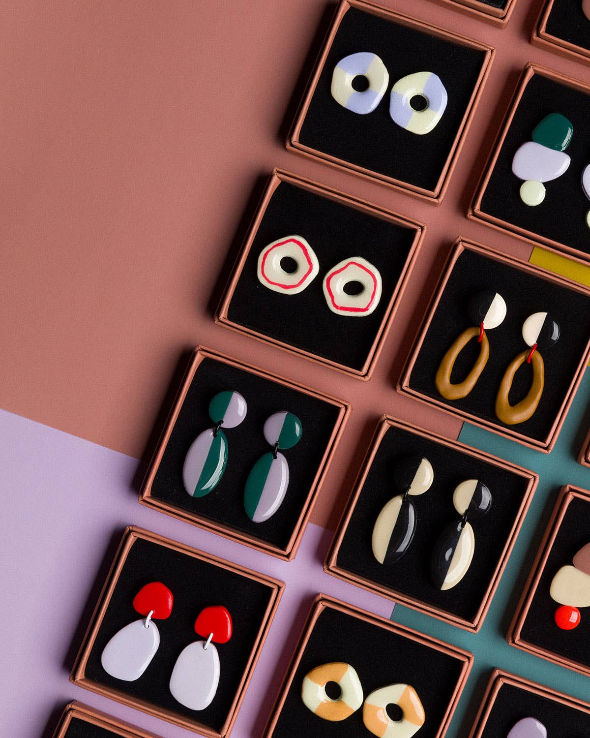Collection of earrings in display cases on a colorful background