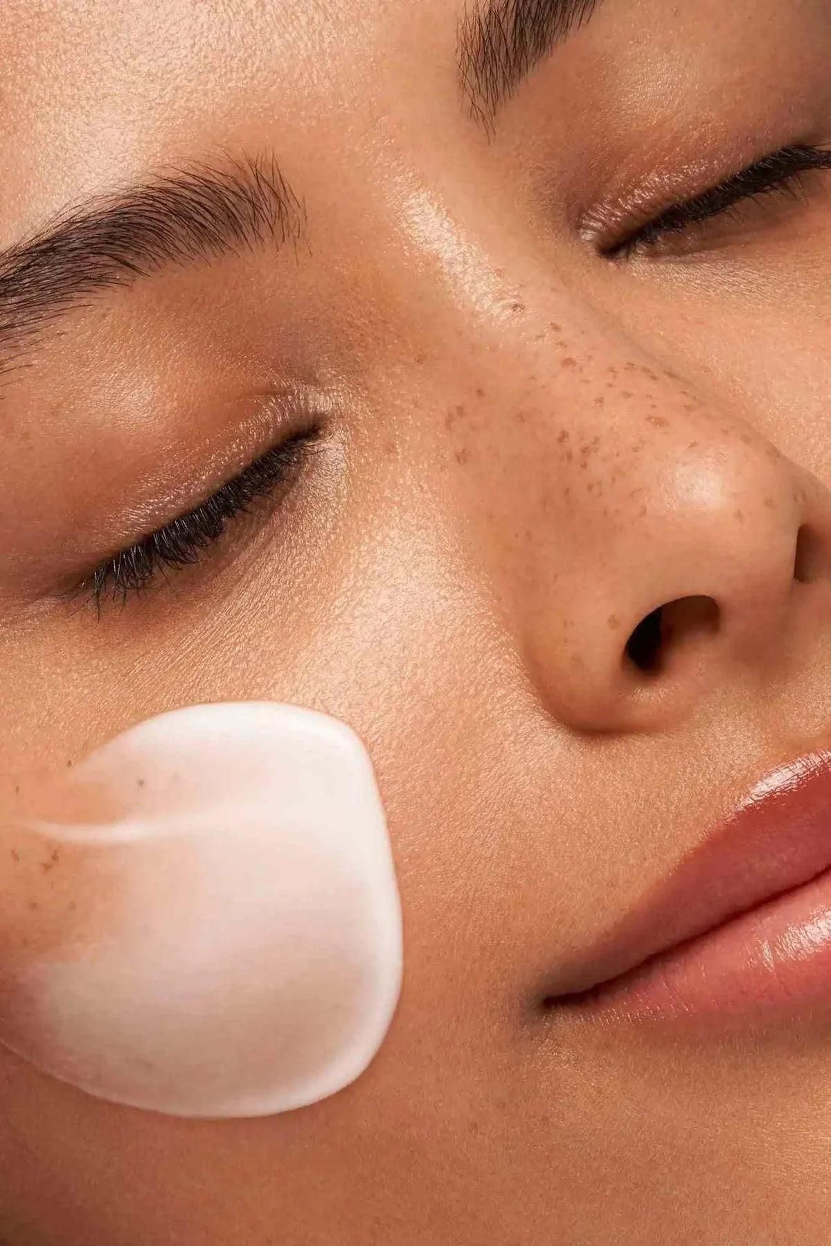Face skincare application with white cream on cheek, demonstrating gentle cleansing with Made With Care - Clear Make-Up Removal