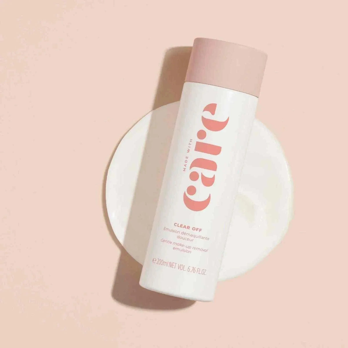 Made With Care - Clear Make-Up Removal gentle cleansing lotion in a white bottle with pink cap on a light pink background
