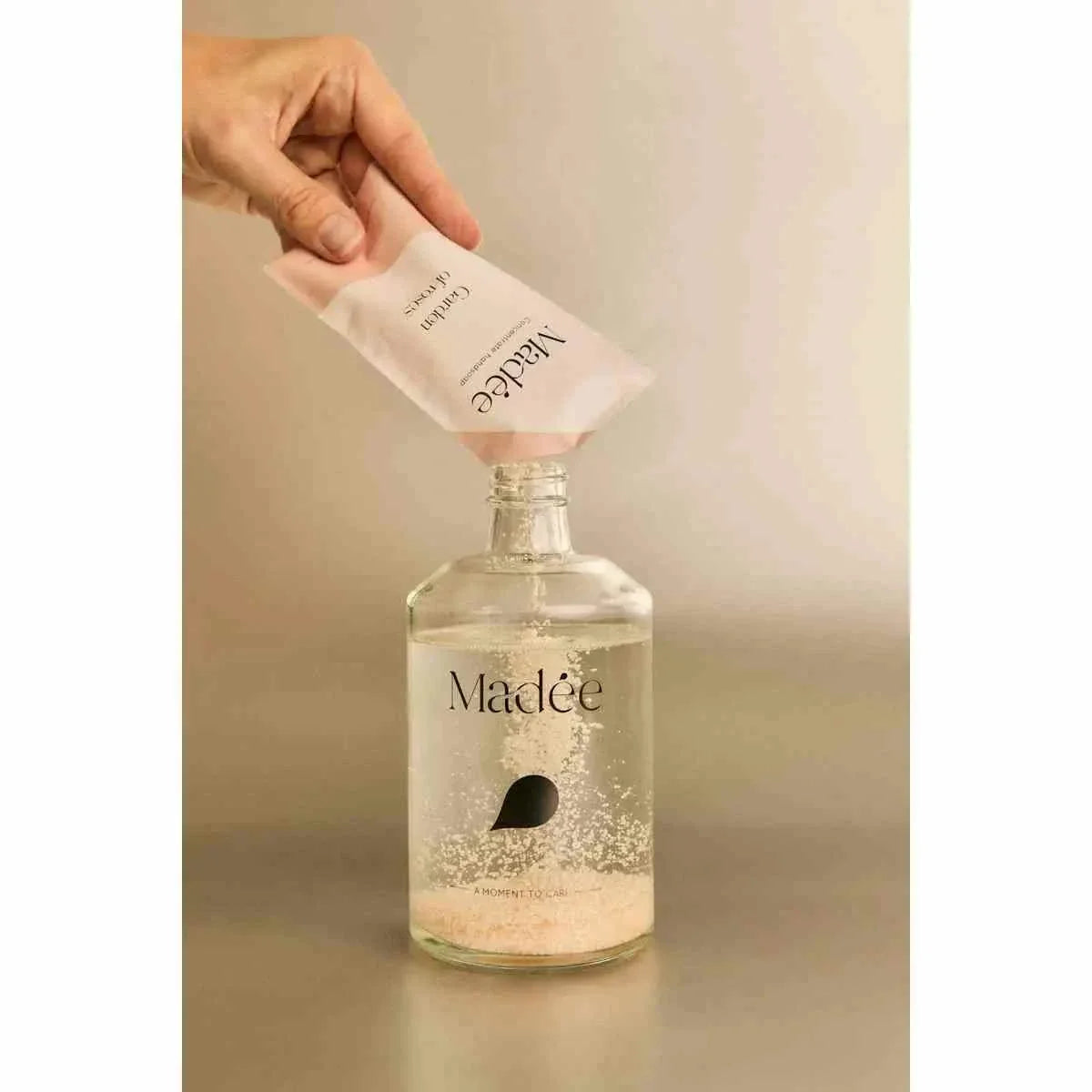 Madée Glass Hand Soap Set with transparent glass bottle and light pink refill pouch being poured, minimalist design