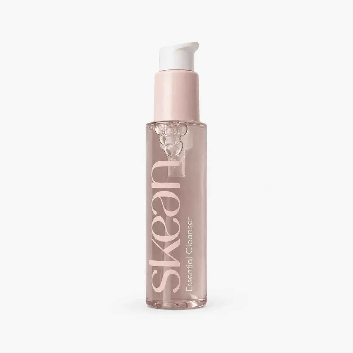 SkeanBeauty Essential Cleanser in a clear pink-tinted bottle with a white pump dispenser and light foam inside