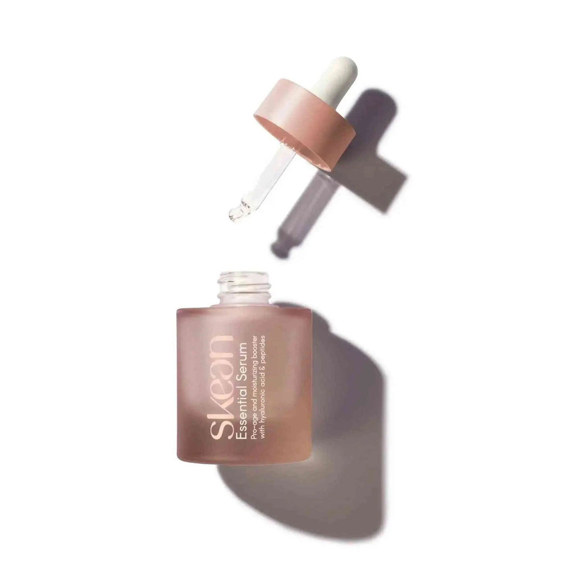 SkeanBeauty Essential Serum in a frosted pink glass bottle with a dropper cap and clear liquid serum inside