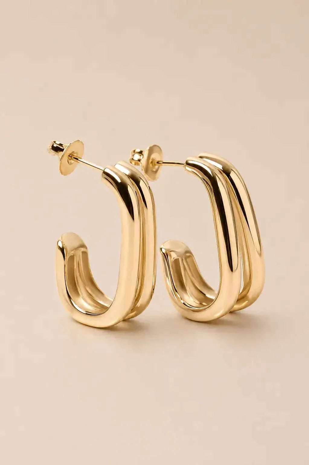 WAEKURA Mona earrings with elegant gold-tone finish and modern minimalist curved rectangular hoop design